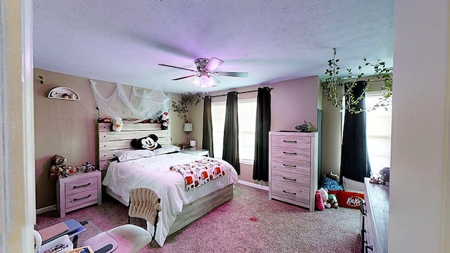 bedroom featuring light carpet, ceiling fan, and a textured ceiling