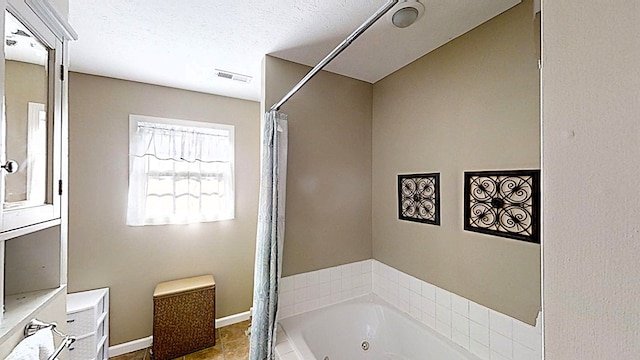 bathroom with baseboards, visible vents, a whirlpool tub, curtained shower, and a textured ceiling