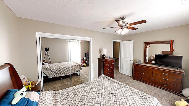 carpeted bedroom featuring a closet, ceiling fan, and a textured ceiling