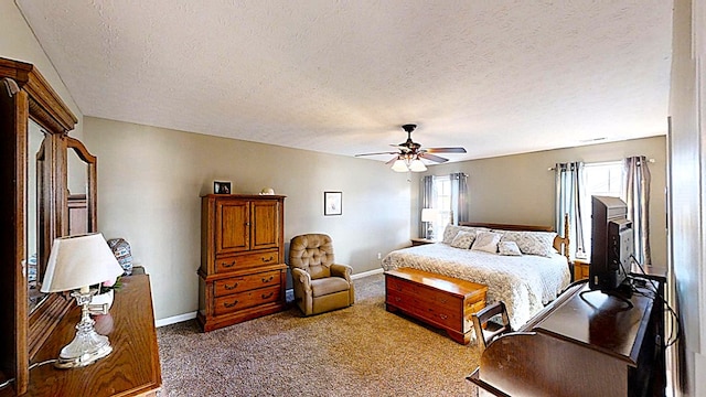 carpeted bedroom featuring a textured ceiling, a ceiling fan, and baseboards