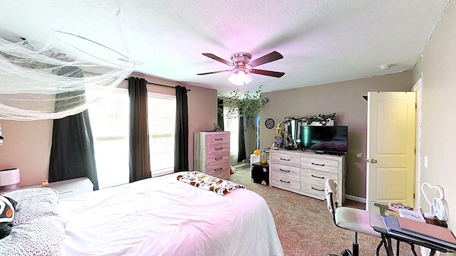 bedroom featuring light carpet, ceiling fan, and a textured ceiling