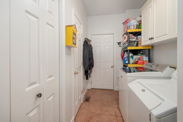 washroom featuring washing machine and dryer, cabinet space, visible vents, and light tile patterned flooring