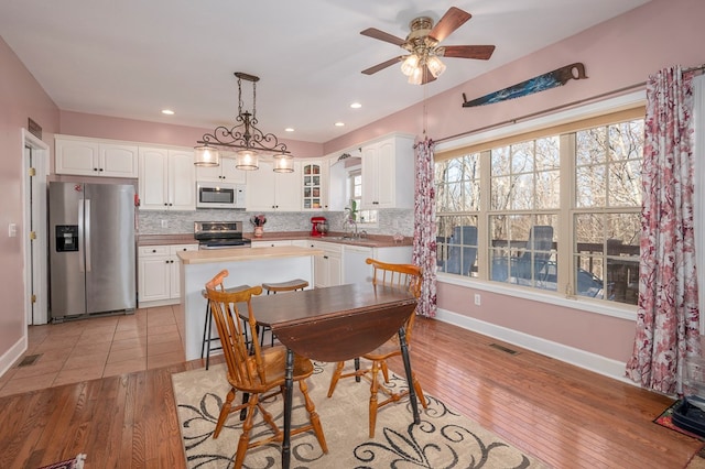 dining area with baseboards, recessed lighting, visible vents, and light wood-style floors