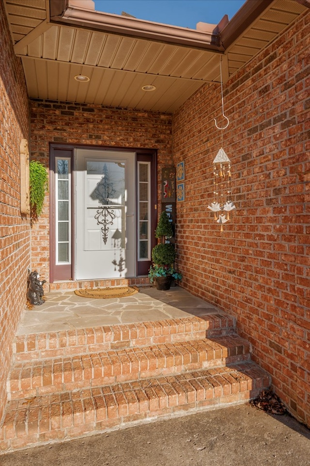 view of exterior entry featuring brick siding