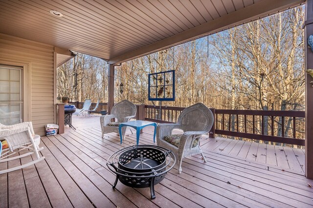 wooden terrace featuring an outdoor fire pit