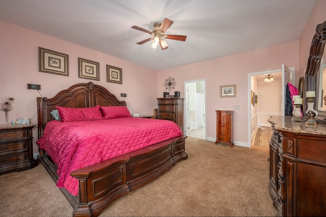 bedroom with light carpet, ceiling fan, ensuite bath, and baseboards