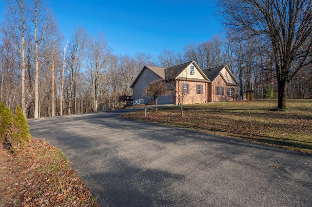 exterior space featuring aphalt driveway and a front yard