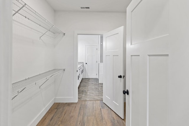 walk in closet with visible vents and wood finished floors