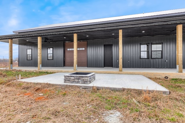 rear view of property with an outdoor fire pit and board and batten siding