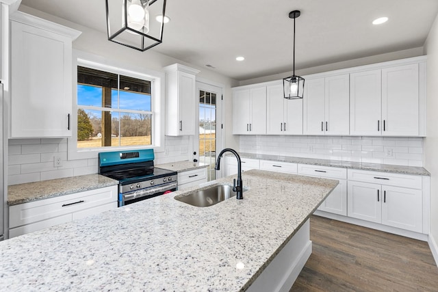 kitchen featuring white cabinets, dark wood-style floors, stainless steel electric stove, pendant lighting, and a sink