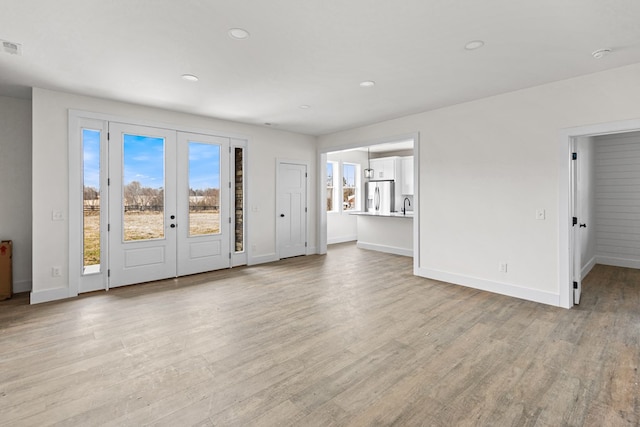 unfurnished living room with light wood-style floors and baseboards