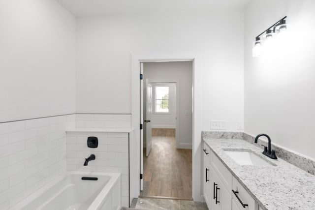 full bathroom with a washtub and vanity