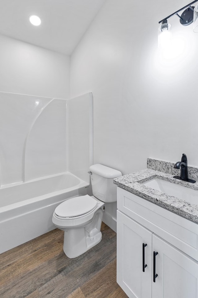 full bathroom with toilet, bathing tub / shower combination, wood finished floors, and vanity