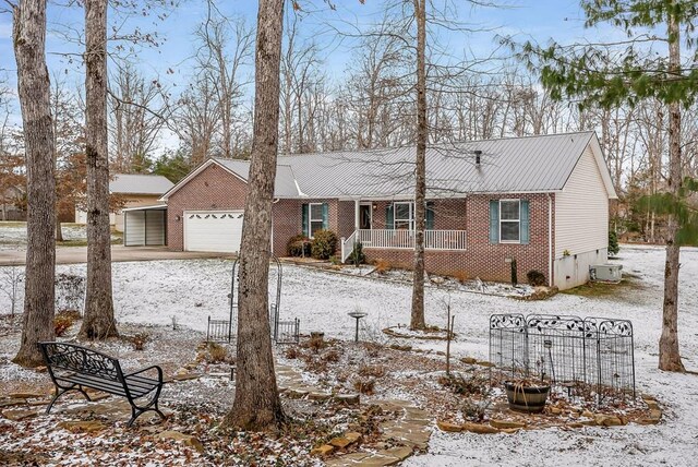 ranch-style home featuring an attached garage, covered porch, and brick siding