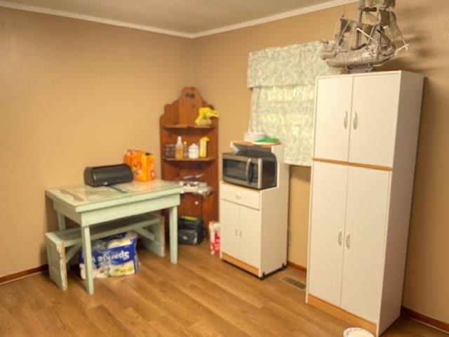 office with baseboards, light wood finished floors, and crown molding