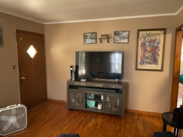 living room featuring ornamental molding, wood finished floors, and baseboards