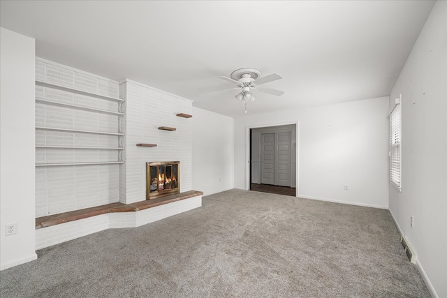 unfurnished living room with baseboards, visible vents, a ceiling fan, carpet floors, and a fireplace