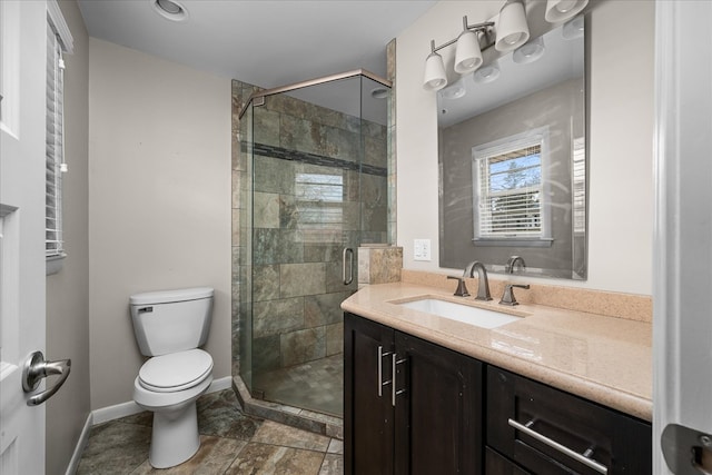 bathroom featuring baseboards, a shower stall, toilet, and vanity