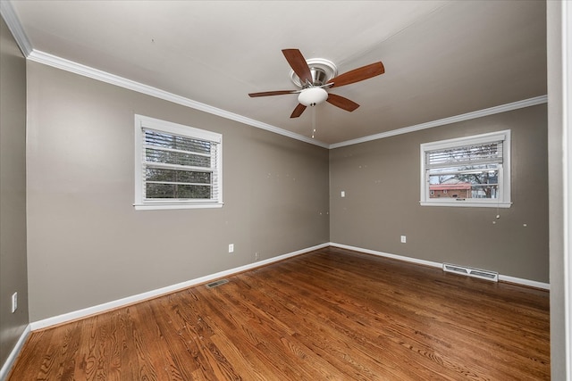 unfurnished room with visible vents, crown molding, baseboards, and wood finished floors