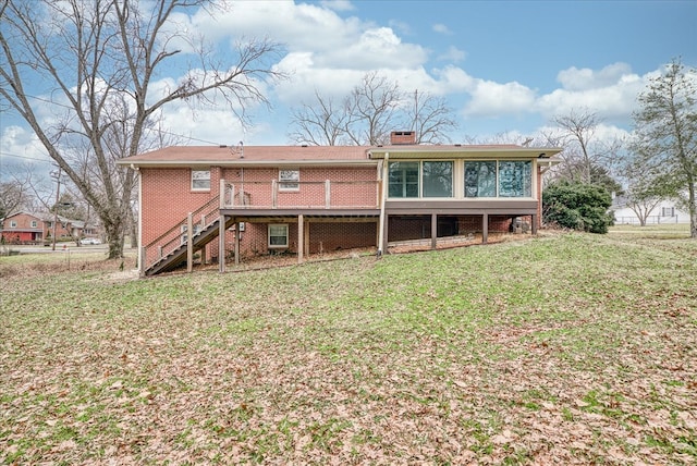 rear view of house with a yard, brick siding, stairway, and a chimney