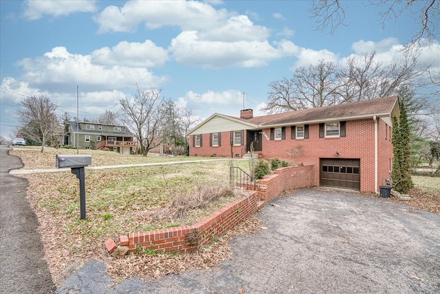 ranch-style house featuring a garage, brick siding, a chimney, and aphalt driveway