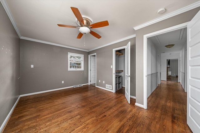 empty room with attic access, visible vents, dark wood finished floors, and baseboards