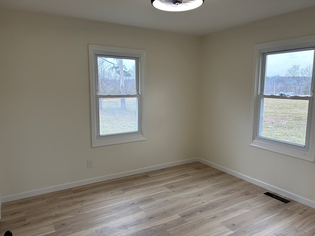 spare room with visible vents, baseboards, and light wood-style floors