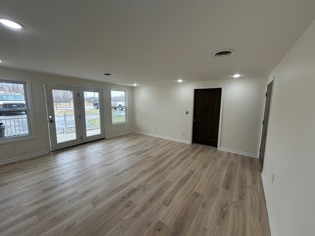 unfurnished room featuring light wood-type flooring, visible vents, baseboards, and recessed lighting