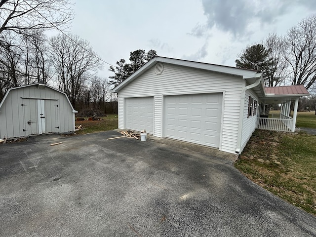 garage with a porch and driveway