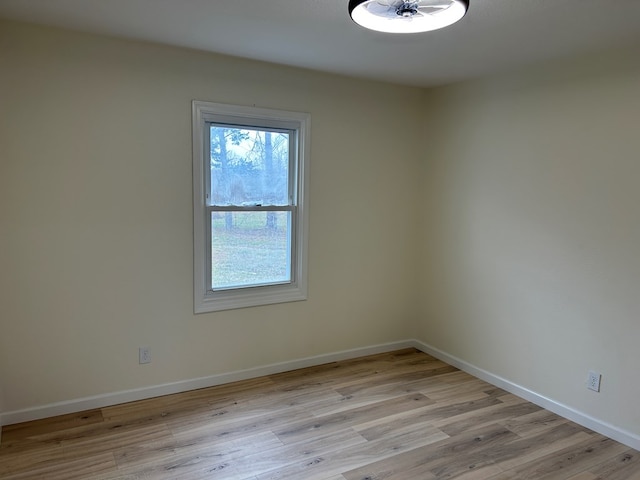 spare room featuring light wood-style floors and baseboards