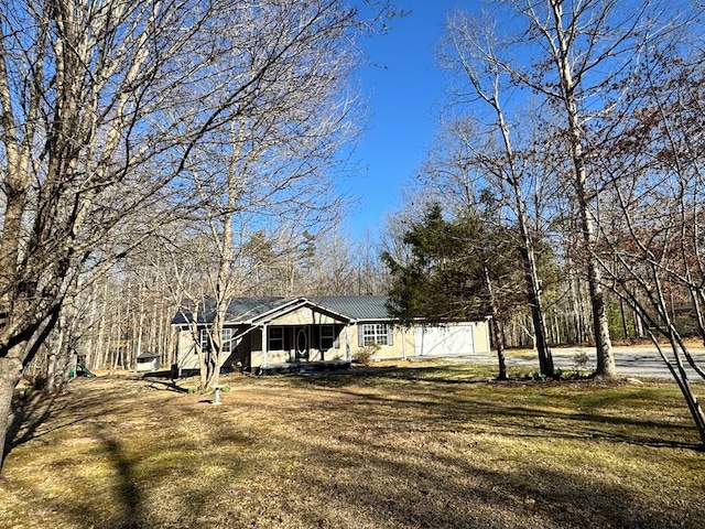 view of front of home with metal roof, a porch, and a front yard