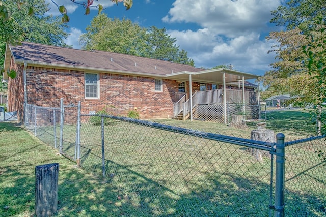 back of house featuring a yard, brick siding, a shingled roof, and fence