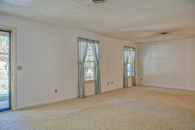 unfurnished room featuring a healthy amount of sunlight, a textured ceiling, and baseboards