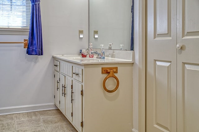 bathroom with vanity, baseboards, and tile patterned floors