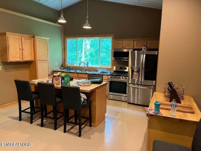 kitchen with stainless steel appliances, lofted ceiling, a center island, and a sink