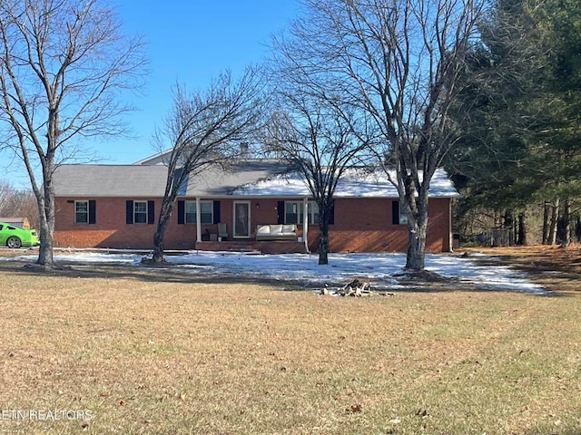 ranch-style home featuring brick siding and a front yard