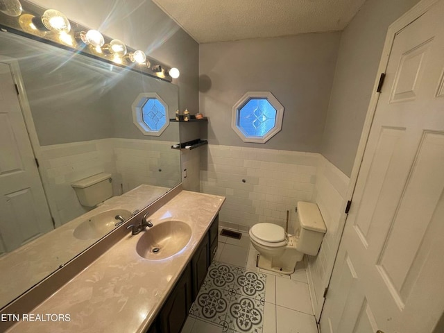 bathroom with toilet, visible vents, a textured ceiling, and tile patterned floors