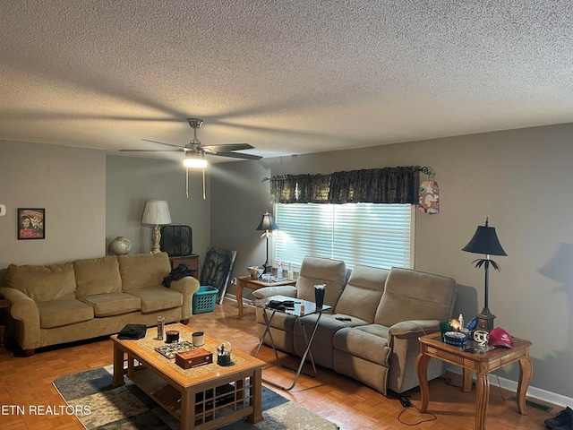 living room featuring a ceiling fan, baseboards, visible vents, and a textured ceiling