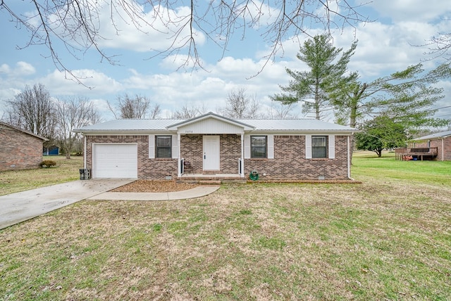 single story home featuring a garage, driveway, metal roof, a front lawn, and brick siding