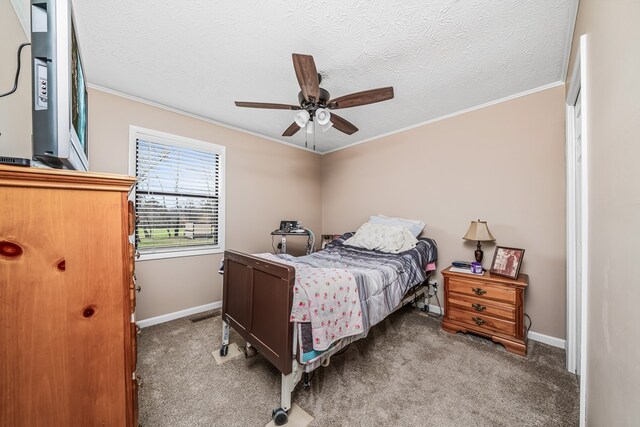 carpeted bedroom with a textured ceiling, baseboards, and crown molding