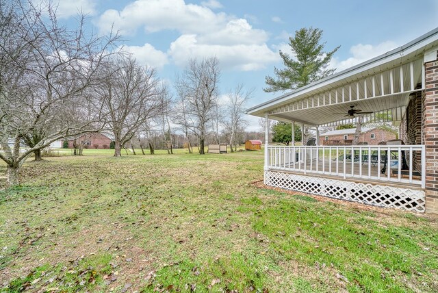 view of yard featuring a deck and a ceiling fan