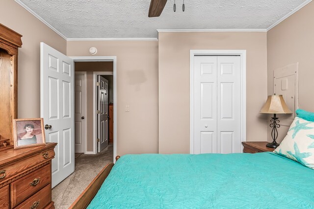 carpeted bedroom featuring crown molding, a textured ceiling, and a closet