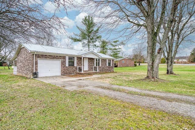 ranch-style home featuring driveway, a garage, metal roof, a front yard, and brick siding