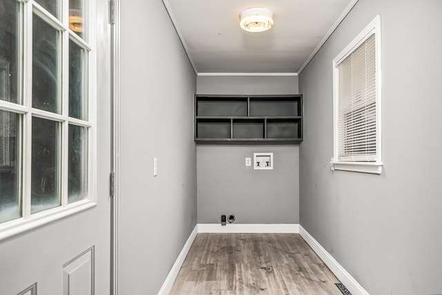 clothes washing area featuring laundry area, washer hookup, wood finished floors, baseboards, and ornamental molding