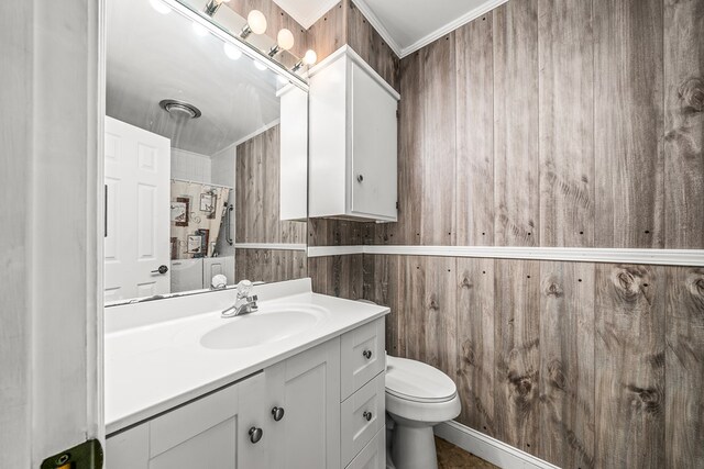 bathroom with toilet, wooden walls, vanity, a shower with curtain, and crown molding