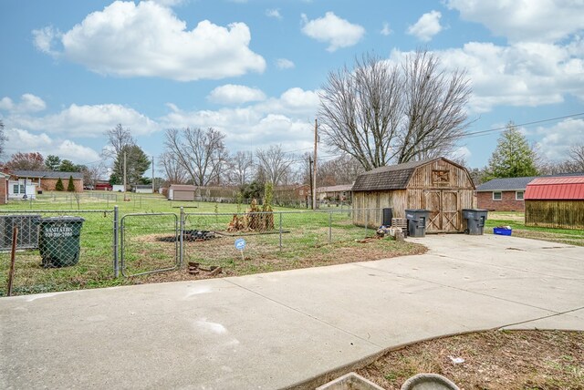 view of yard with a garage, a gate, fence, and an outdoor structure