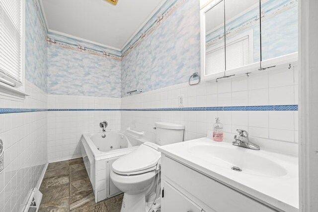 bathroom featuring a wainscoted wall, a jetted tub, toilet, and wallpapered walls