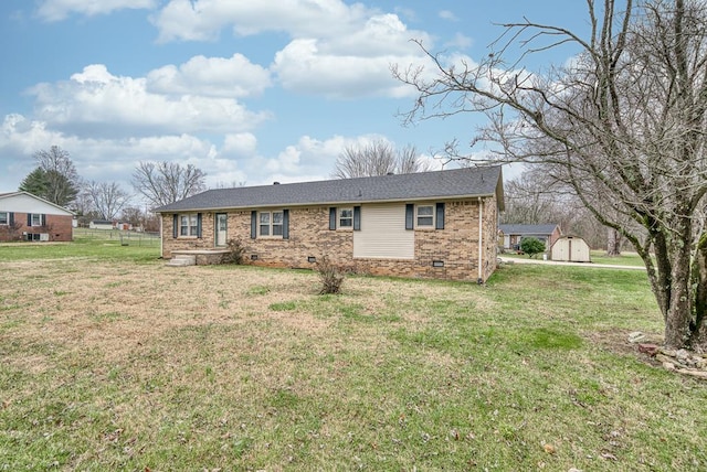 ranch-style house with crawl space, a shed, a front yard, and an outdoor structure