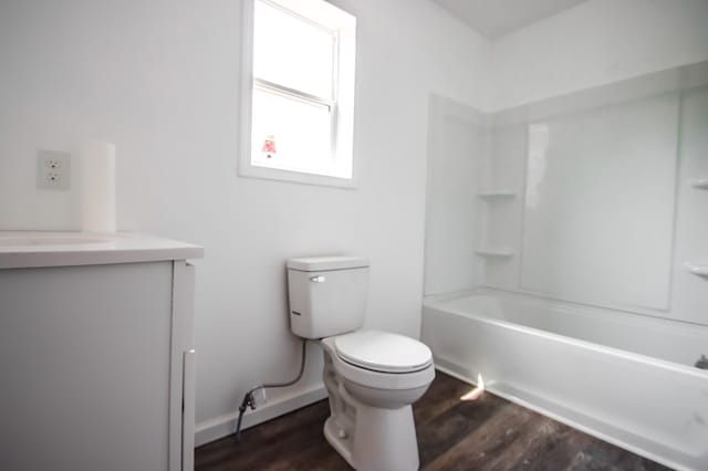 bathroom with toilet, shower / washtub combination, wood finished floors, and vanity