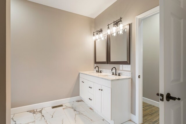 full bathroom featuring double vanity, a sink, visible vents, and baseboards